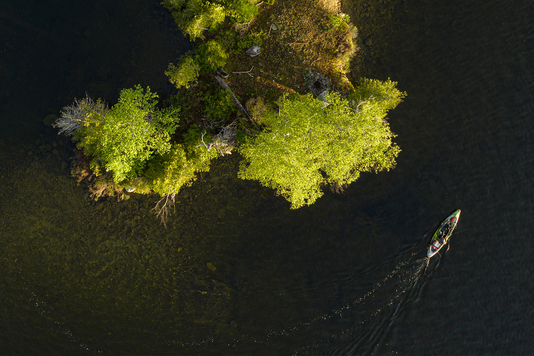 Overhead shot of kayak being paddle beside an island